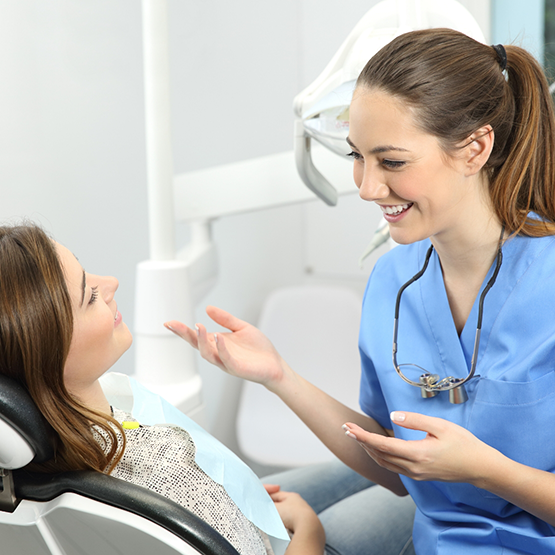 Dentist smiling while talking to a patient