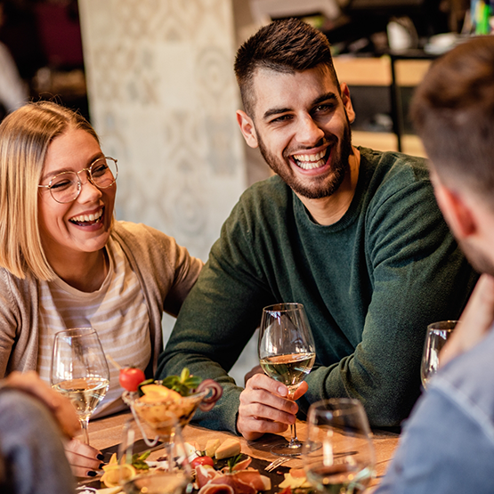 Group of adults laughing together at dinner