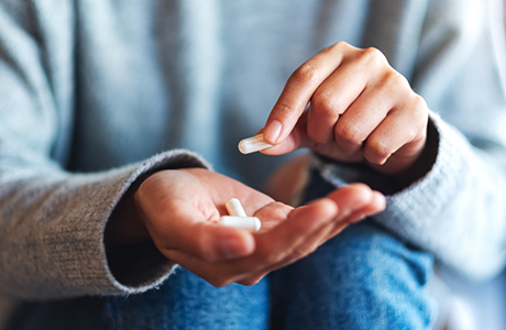Person taking a white pill
