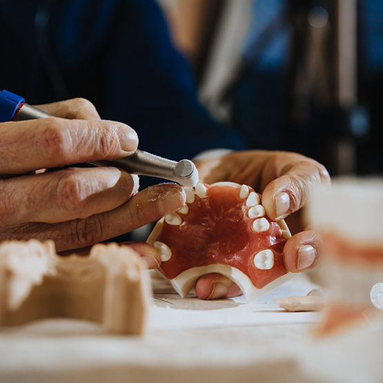 Dental professional cleaning a denture