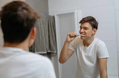 Man brushing his teeth at home