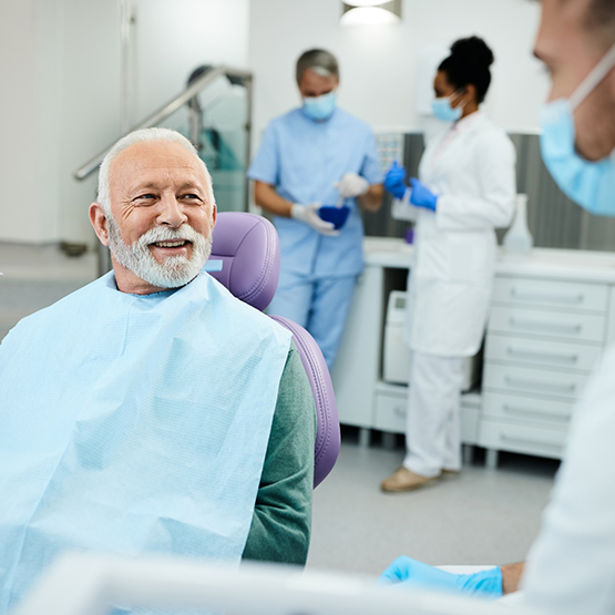 Senior man in the dental chair talking to his dentist