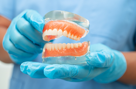 Dentist holding a model of dentures