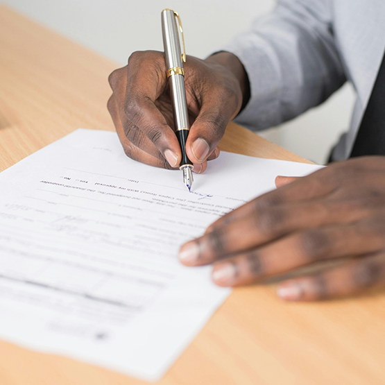 Person filling out paperwork at a desk