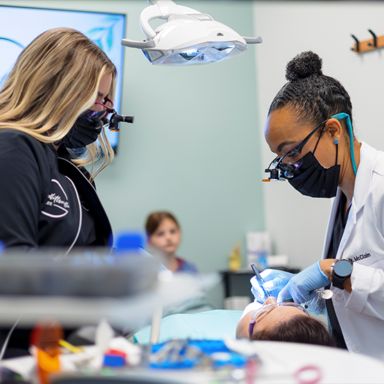 Doctor McClain and a dental assistant treating a patient