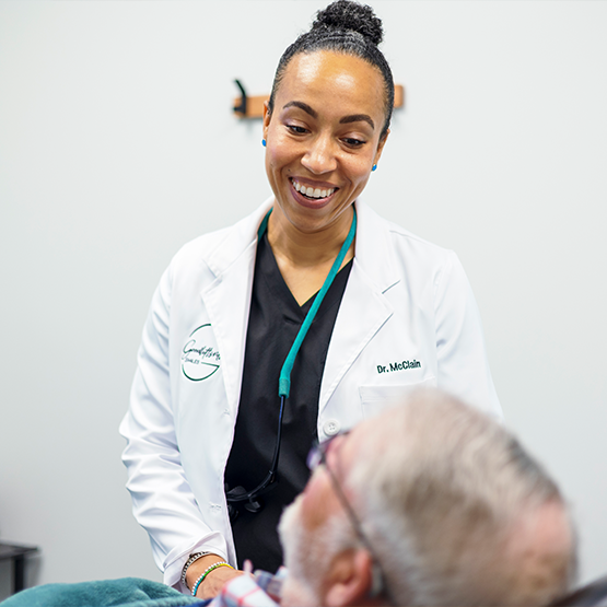 Doctor McClain talking to a man in the dental chair