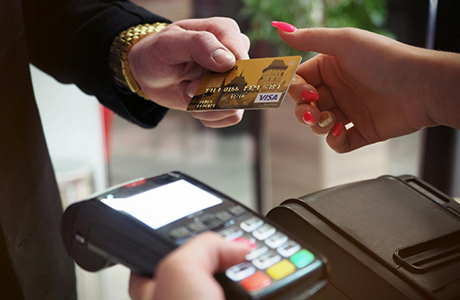 Person handing their payment card to a receptionist