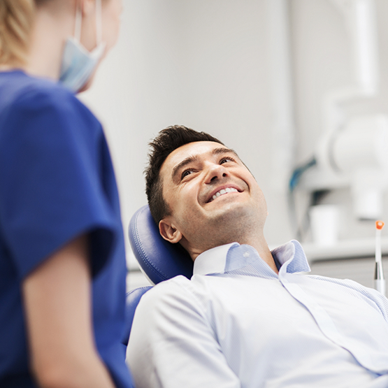 Man leaning back in the dental chair and listening to his dentist