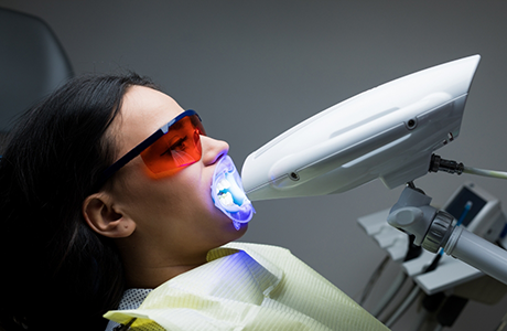 Woman getting professional teeth whitening in the dental chair