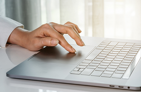 Close up of a person using their laptop at a table