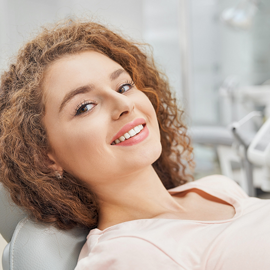 Smiling woman leaning back in the dental chair