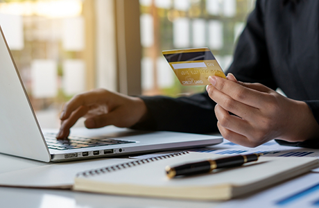 Person entering their credit card information onto a laptop