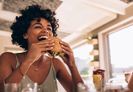 Woman smiling while eating lunch at restaurant