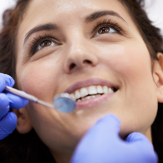 Woman looking up at her dentist during a checkup