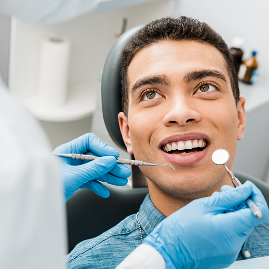 Man in the dental chair listening to his dentist