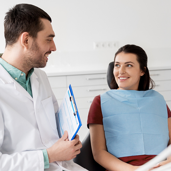 Woman in the dental chair talking to her dentist about laser dentistry