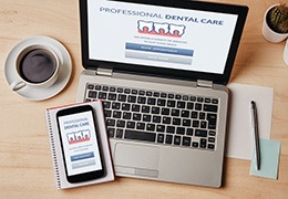 Dental insurance forms on laptop next to cup of coffee