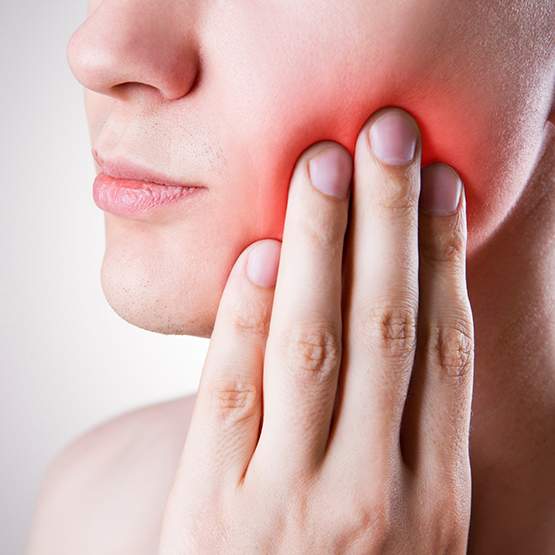 Person holding their cheek in pain before root canal treatment in Goodlettsville