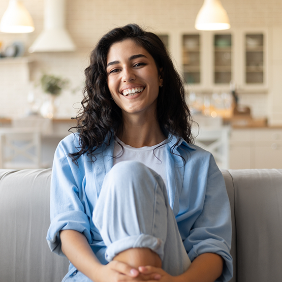 Woman with wavy brown hair smiling after getting tooth colored fillings in Goodlettsville